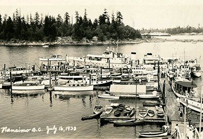 A black and white photo of boats in a harbor with the date july 4 1938