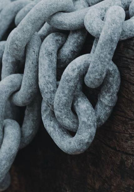 A close up of a chain on a wooden surface.