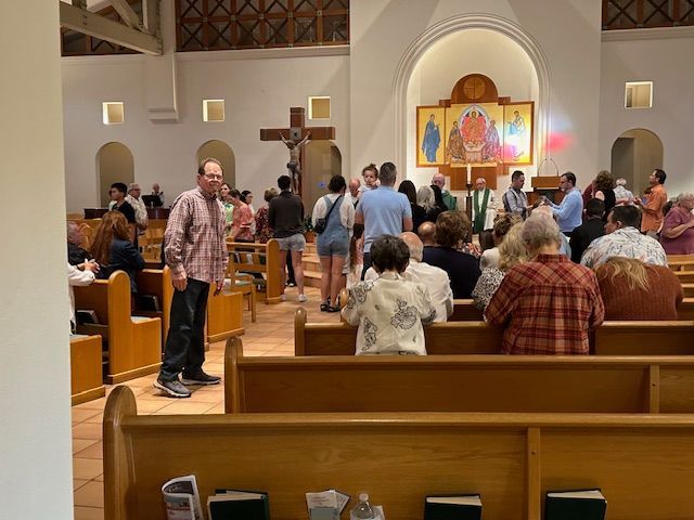 Inside church, usher guiding people to receive communion