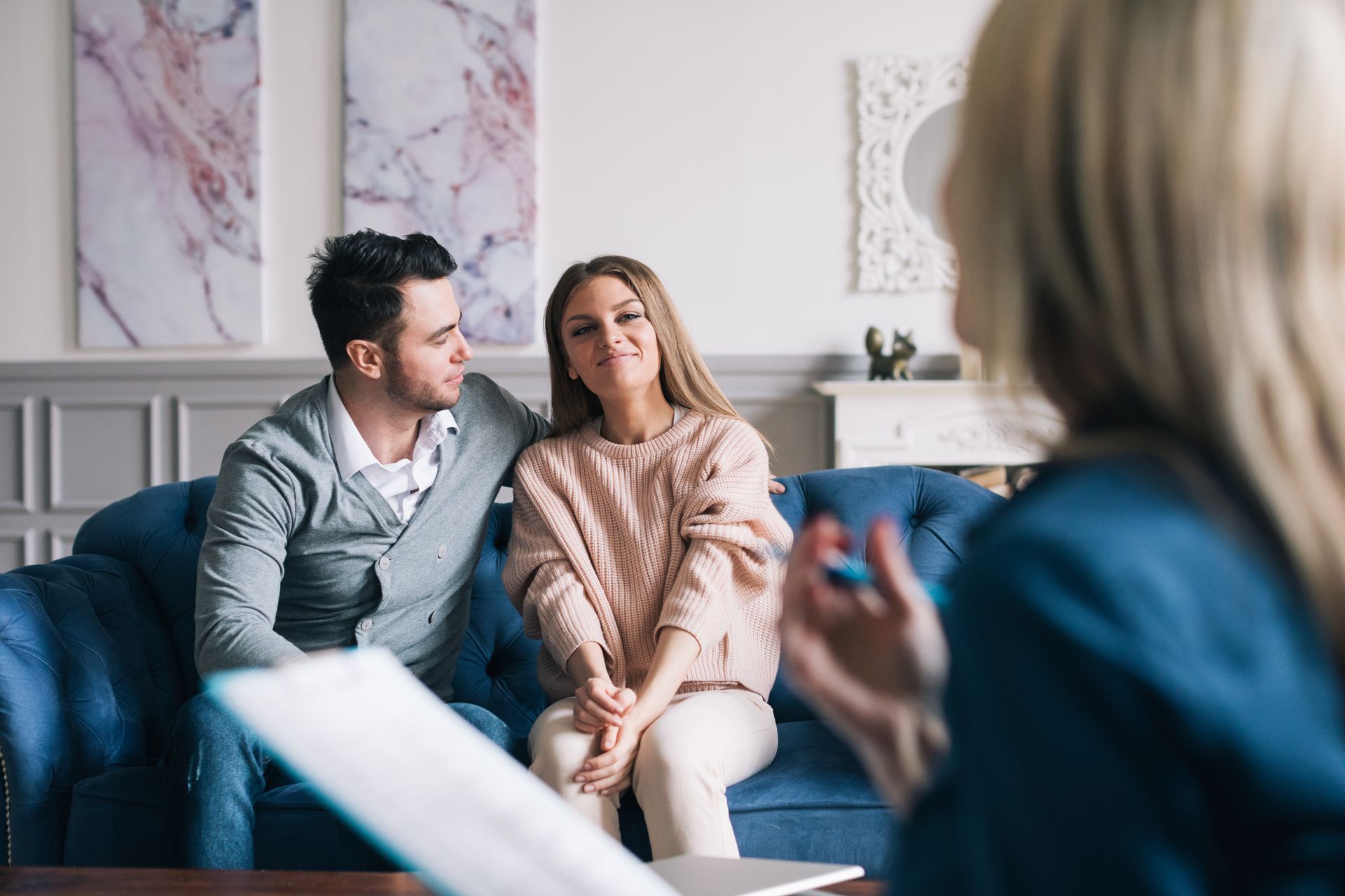 Couple talking with a therapist in a bright living room during a counseling session