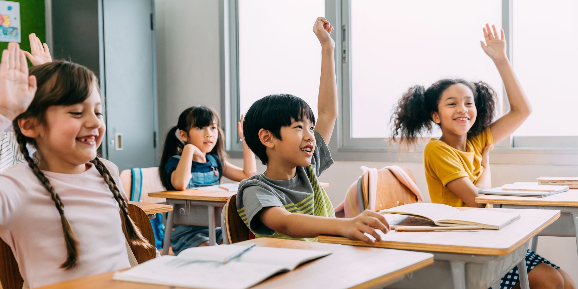 Kids' classroom with students raising their hand