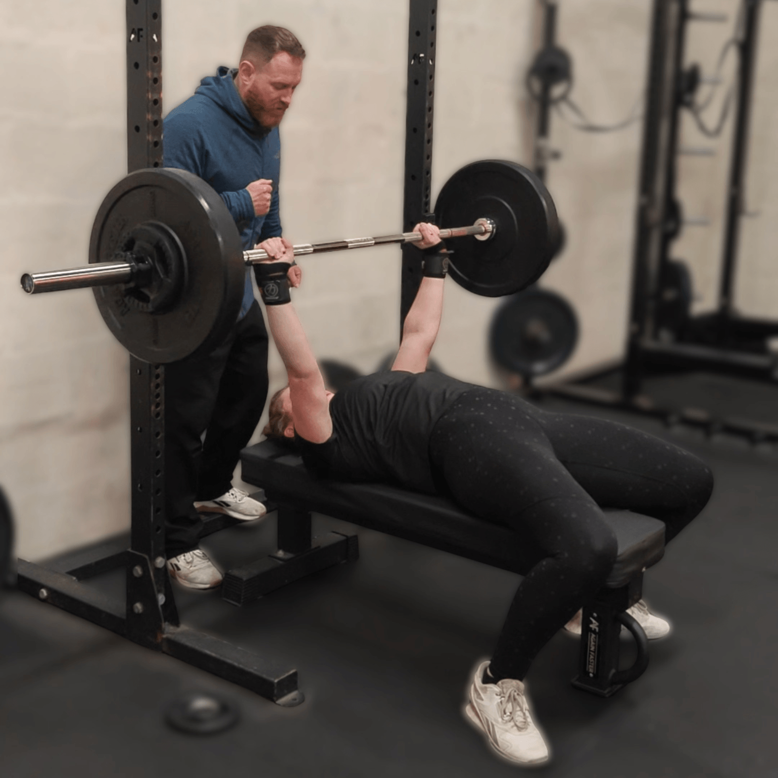Woman bench pressing with Glasgow personal trainer