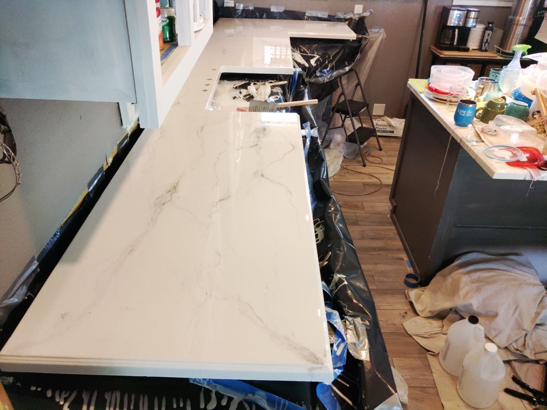 A kitchen with a counter top that is being painted