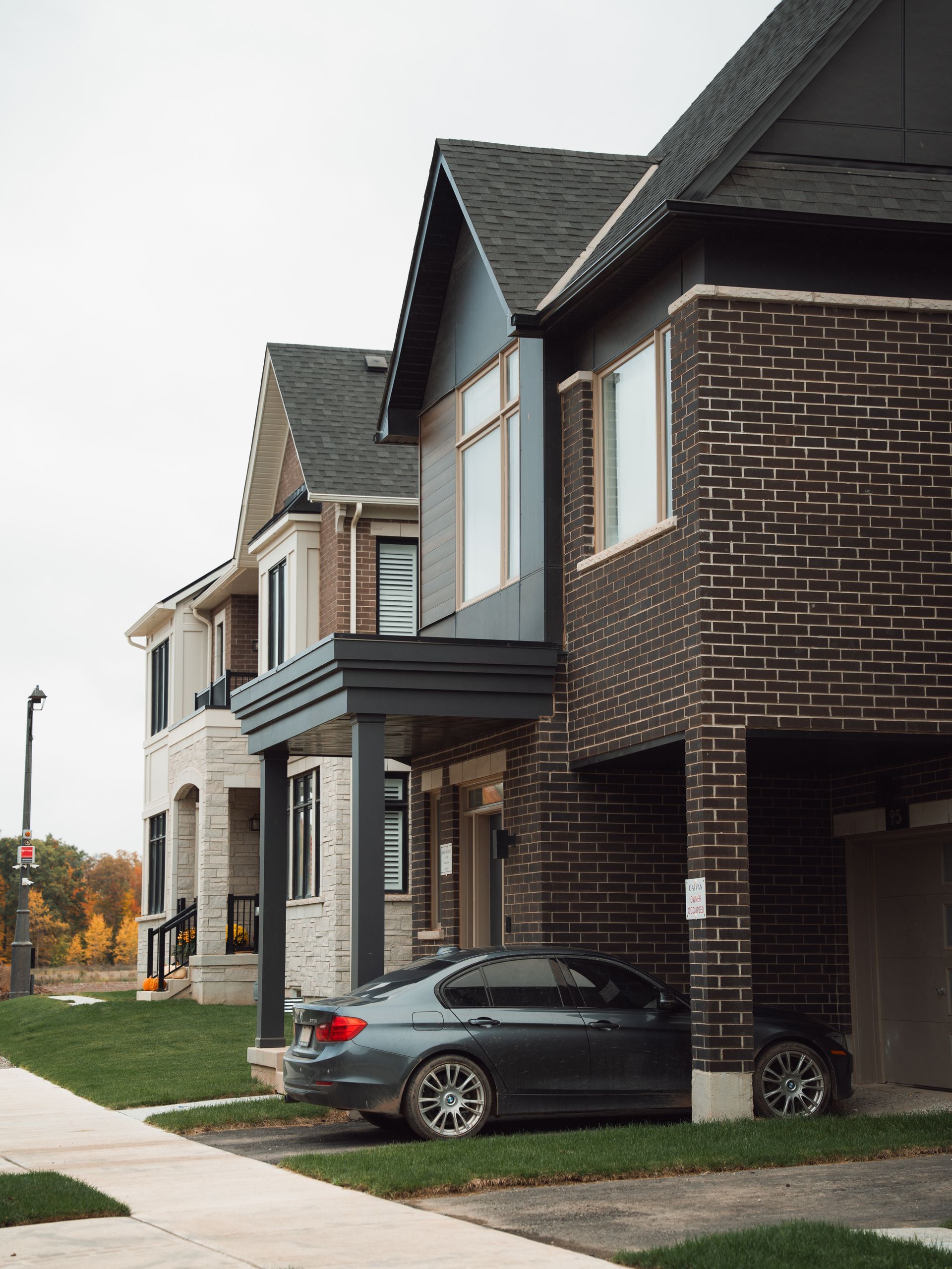Row of modern townhouses with a gray car parked in front on a residential street