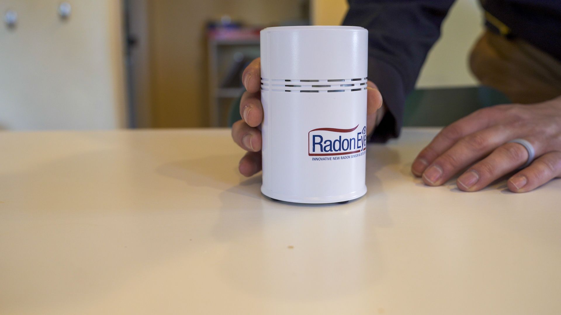 A person is holding a small white container that says rado on it