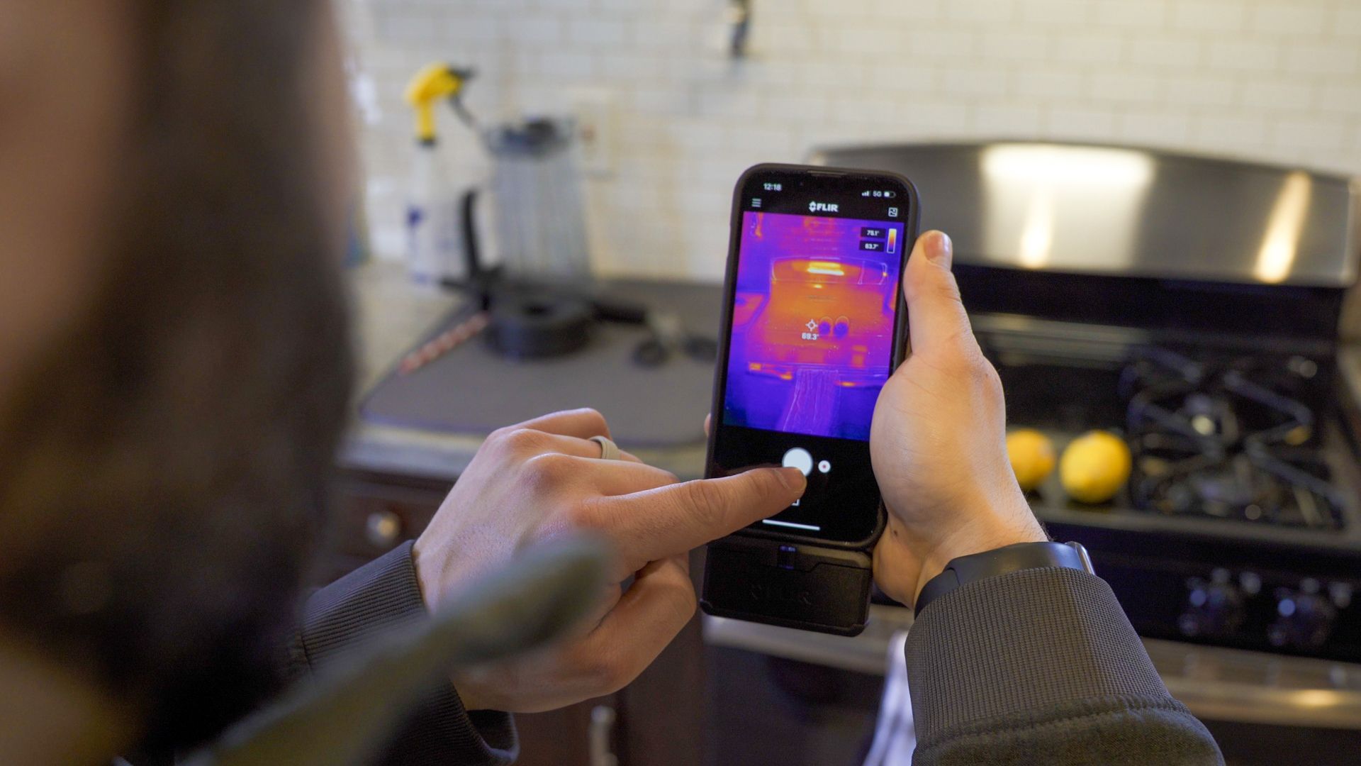 A person is taking a picture of a stove with a cell phone