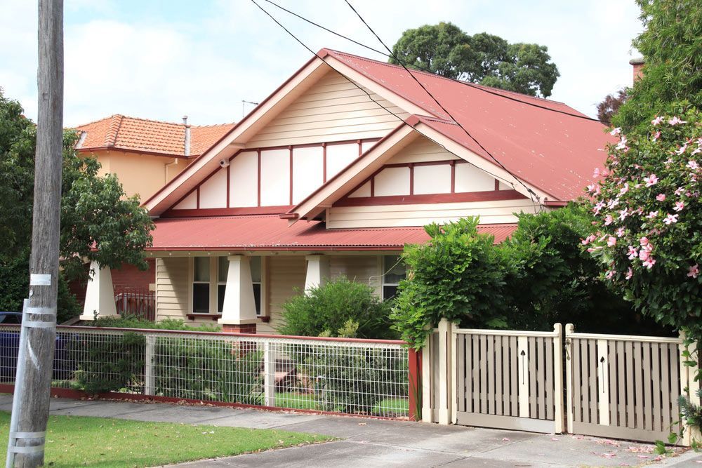 A House With A Red Roof And A White Fence — Glenn Merrick Constructions In Whitsundays, QLD