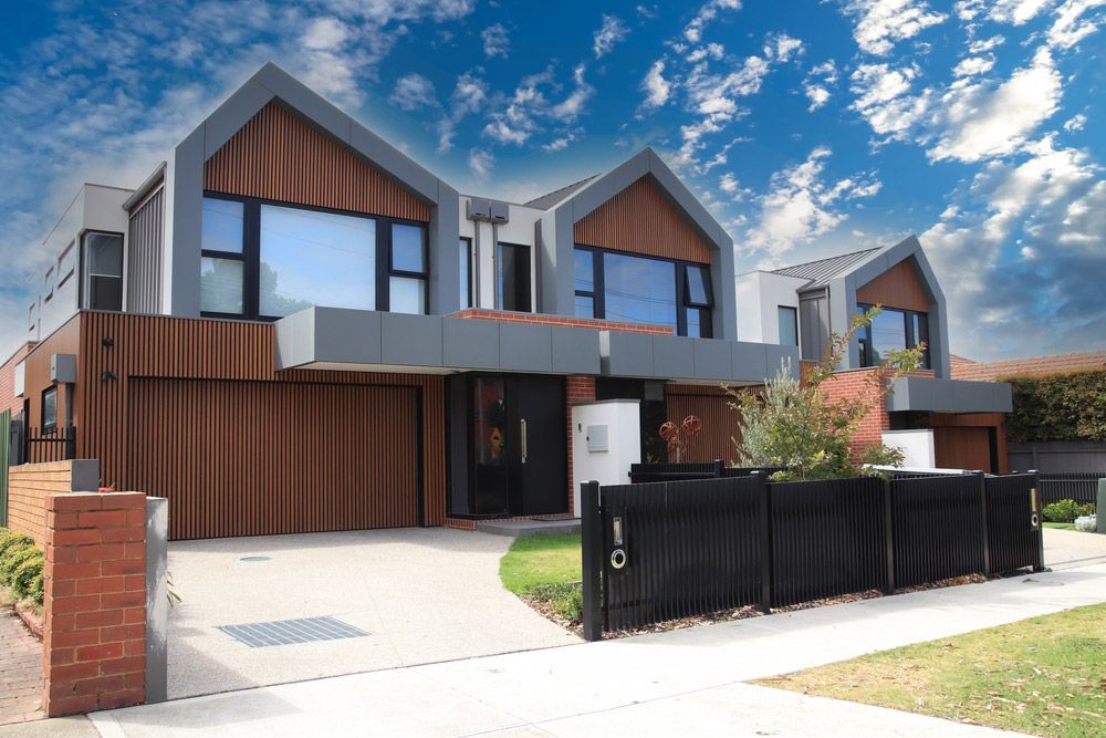 A Modern House With A Black Fence In Front Of It — Glenn Merrick Constructions In Collinsville, QLD