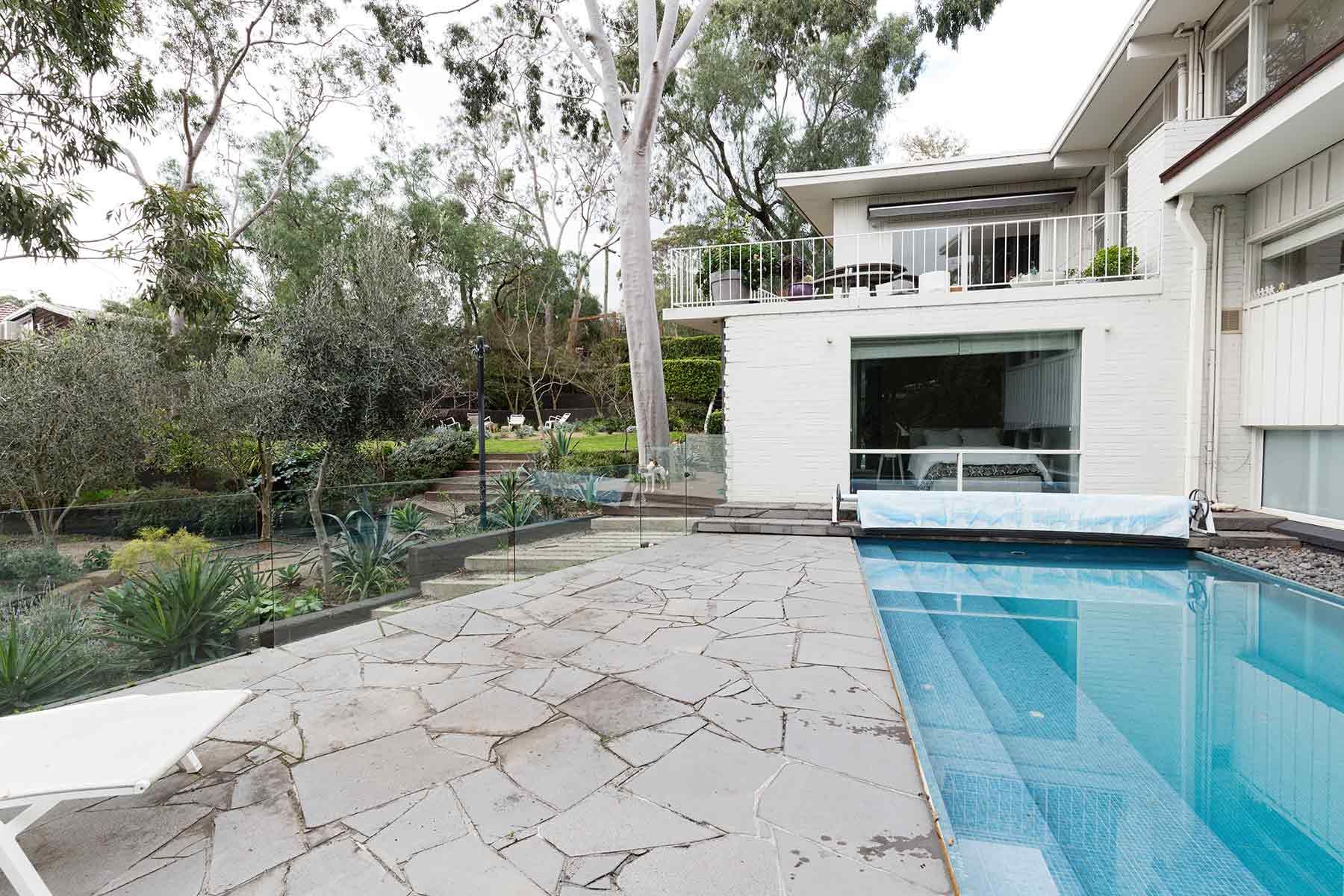 A Large House With A Swimming Pool In Front Of It — Glenn Merrick Constructions In Bowen, QLD