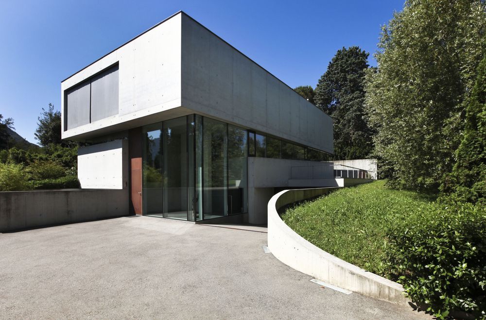 A Modern House With A Lot Of Windows And A Driveway — Glenn Merrick Constructions In Collinsville, QLD