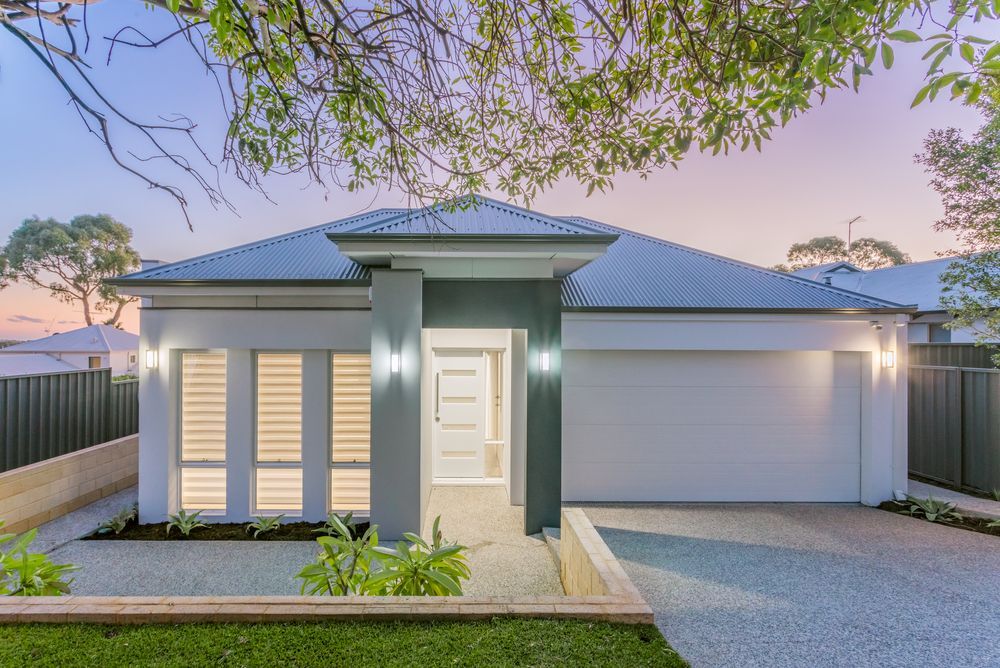 A House With A Green Garage Door And A Brick Wall — Glenn Merrick Constructions In Bowen, QLD