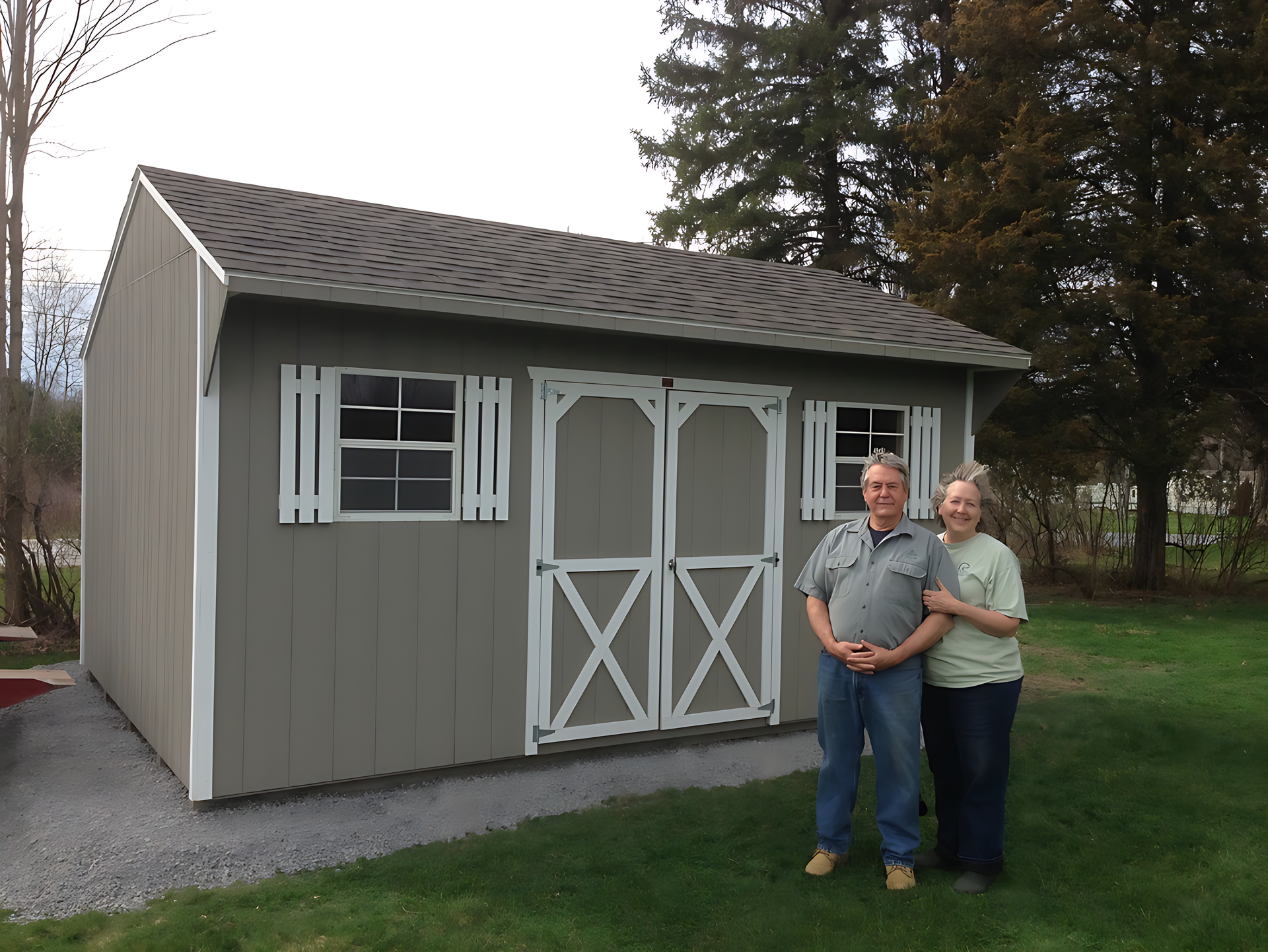 A man and a woman standing in front of a shed