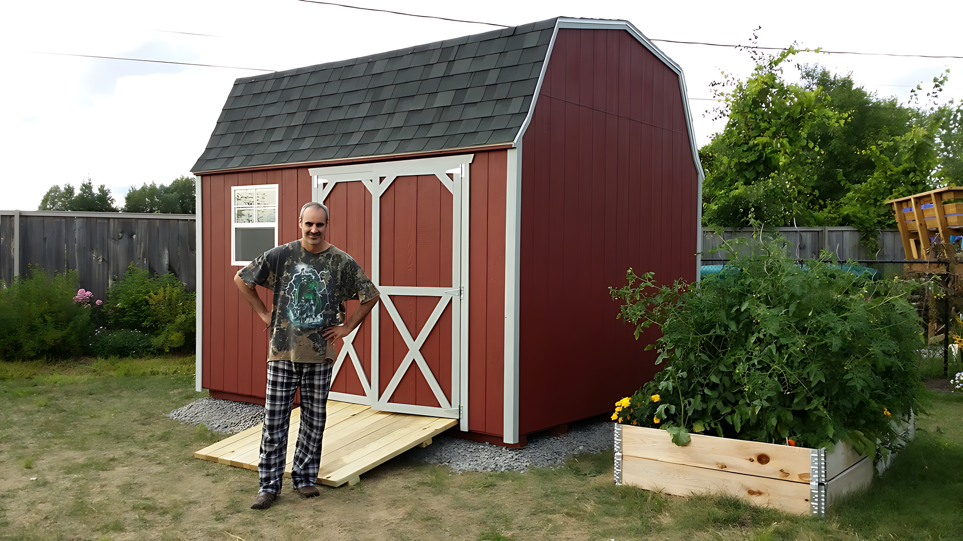 A man standing in front of a red barn with a ramp