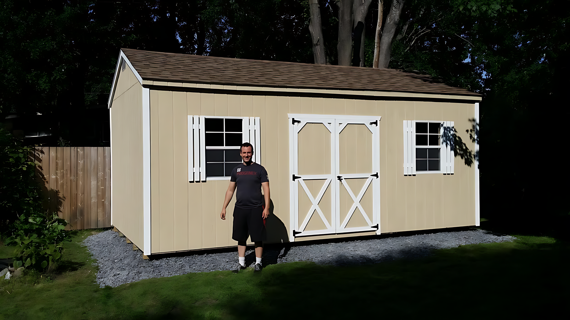 A man is standing in front of a tan shed