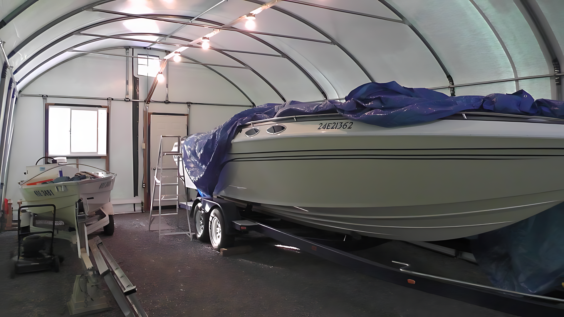 A boat in a garage with a blue tarp on it