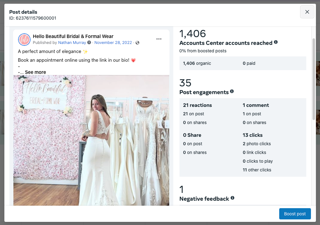 A woman in a wedding dress is standing in front of a wall of wedding dresses.
