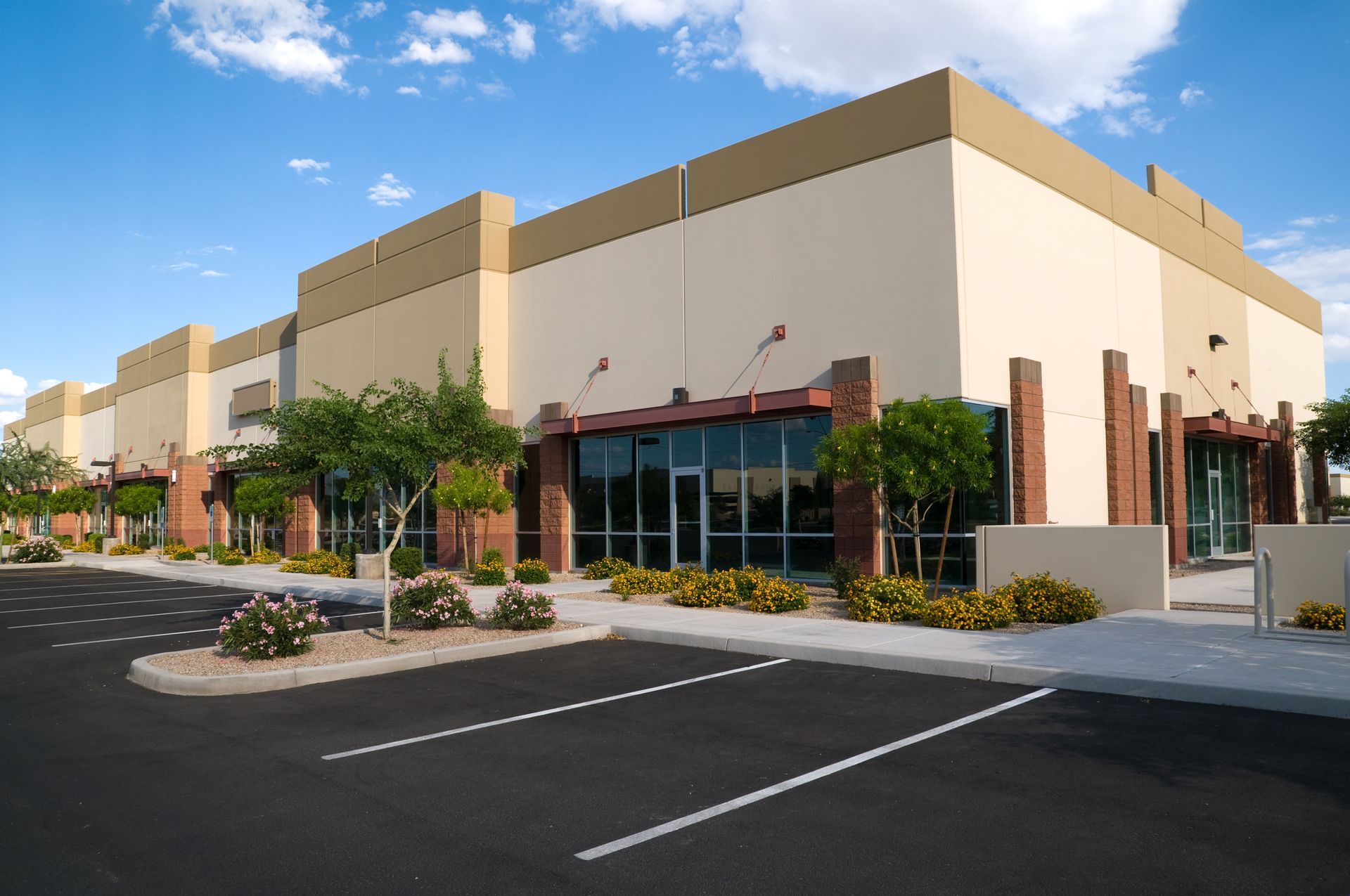 A large building with a lot of windows and a parking lot in front of it