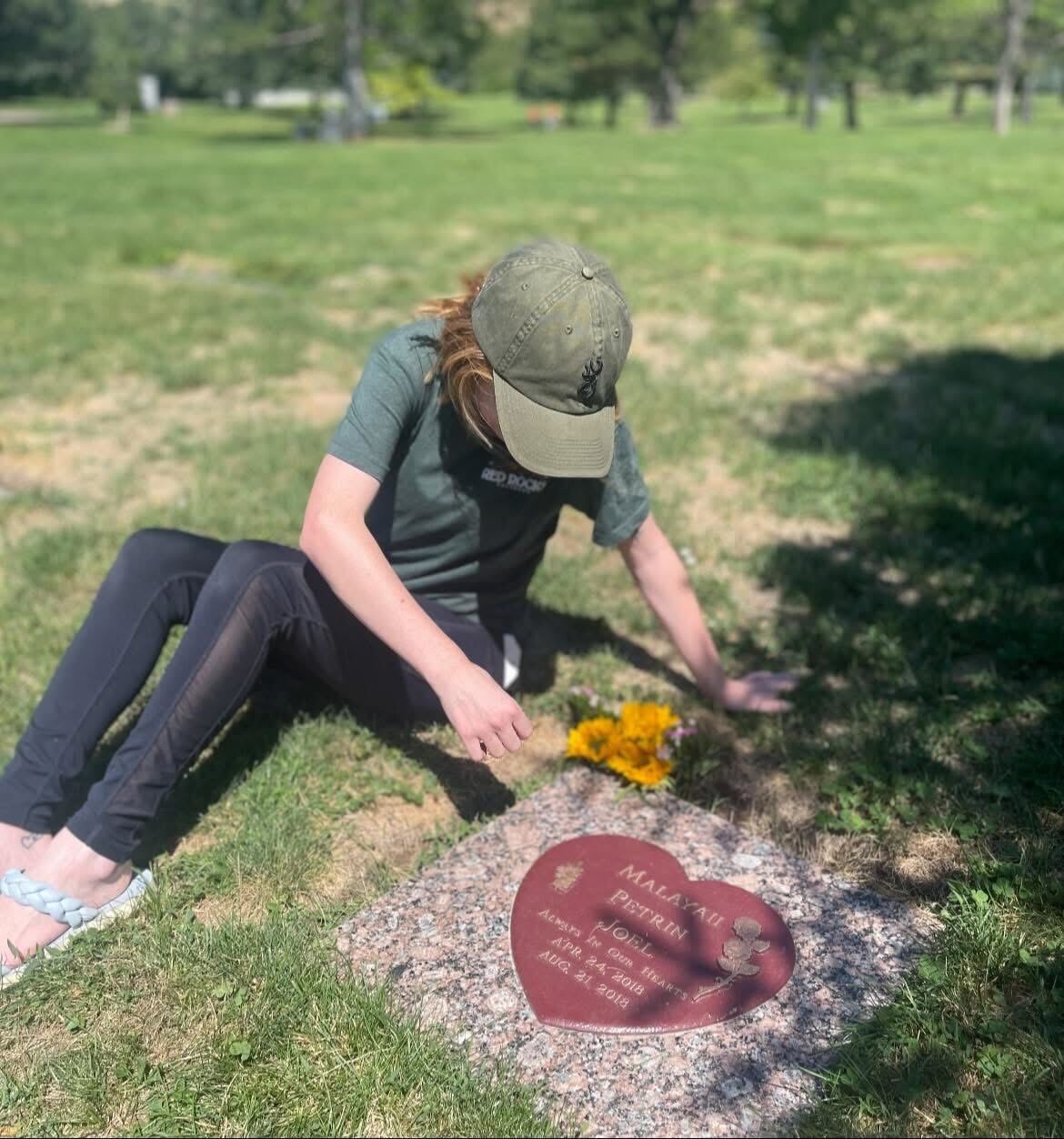Tiara Monson is placing a flower on a grave.