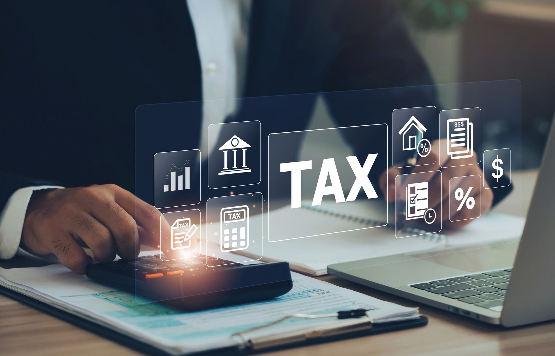 Business tax CPA services professional calculating taxes and reviewing financial records on a laptop