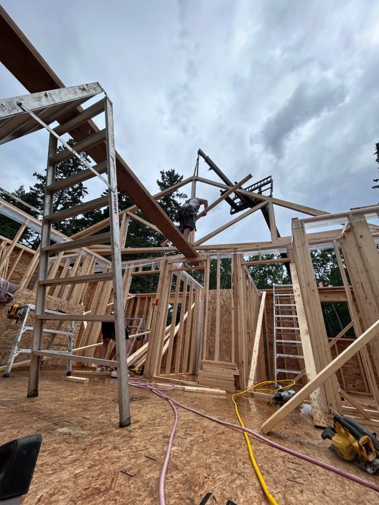 Construction workers framing a wooden building, using a ladder and beams; cloudy sky overhead.