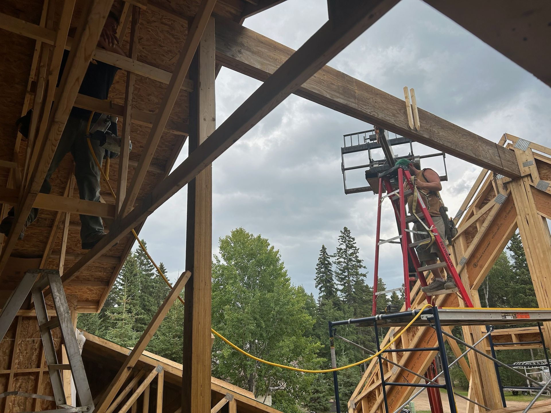 Construction workers building wooden frame of a house, cloudy sky.