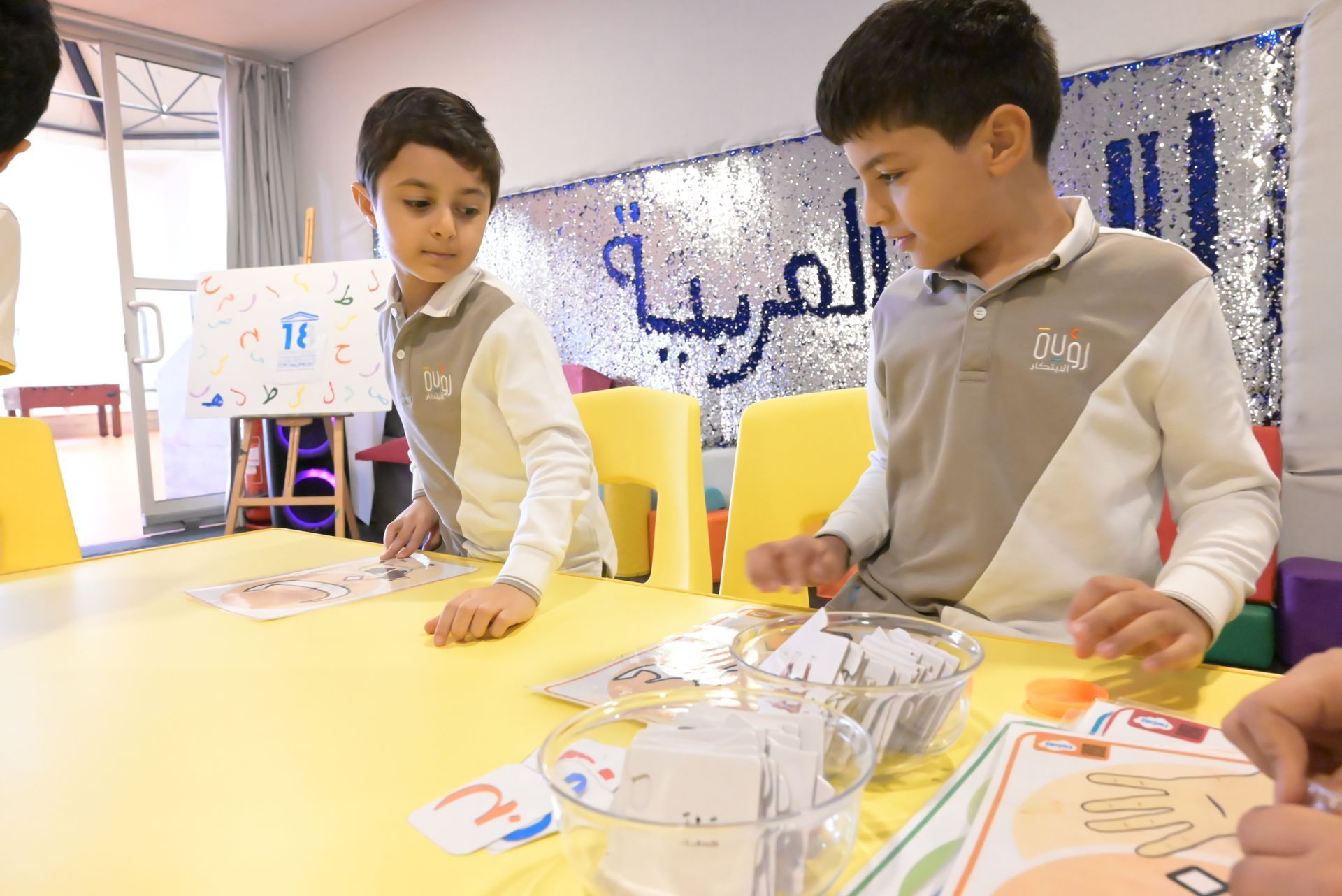 A group of young boys are sitting at a table in a classroom.