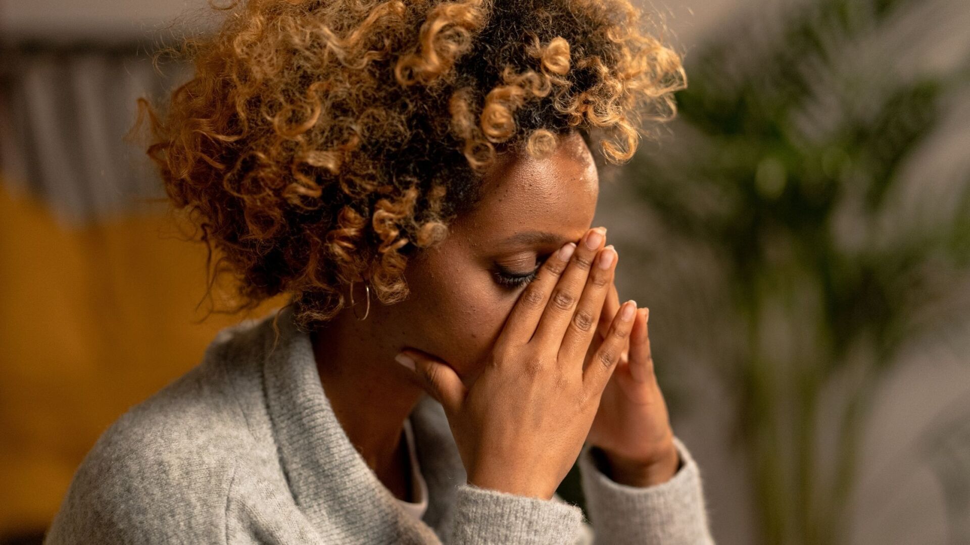 woman with her head resting on both hand eyes closed