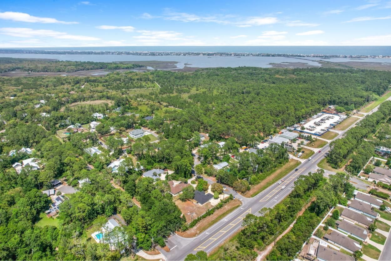 Aerial view of a green suburban neighborhood beside a lake under a blue sky