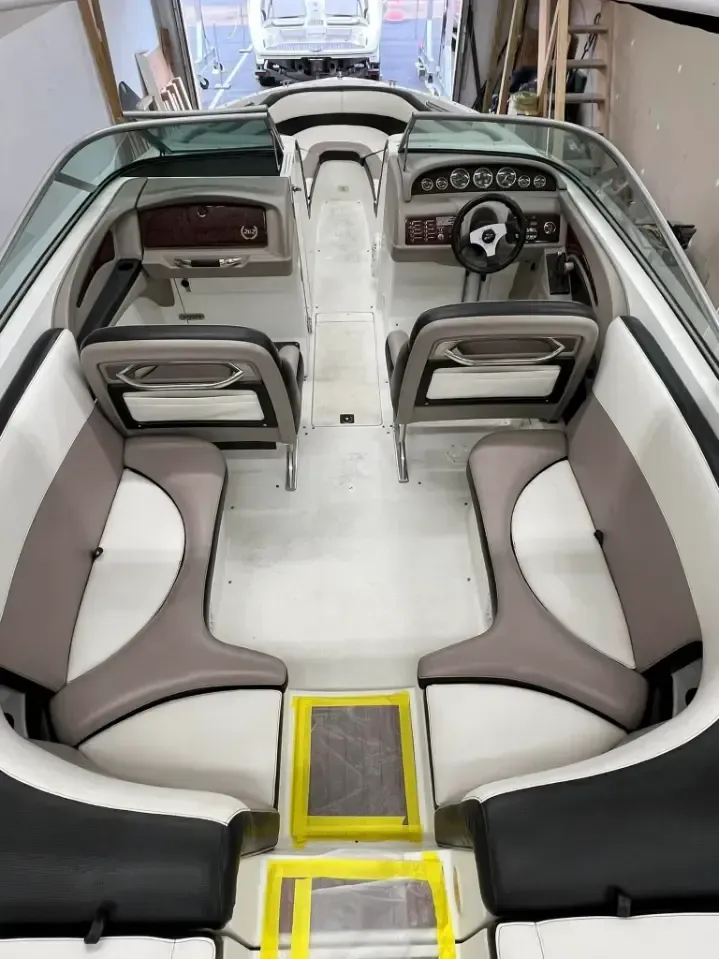 Interior view of a boat with white, gray, and black seats. 
