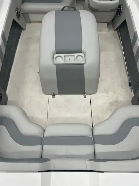 Boat interior with gray and white seating, cup holders.