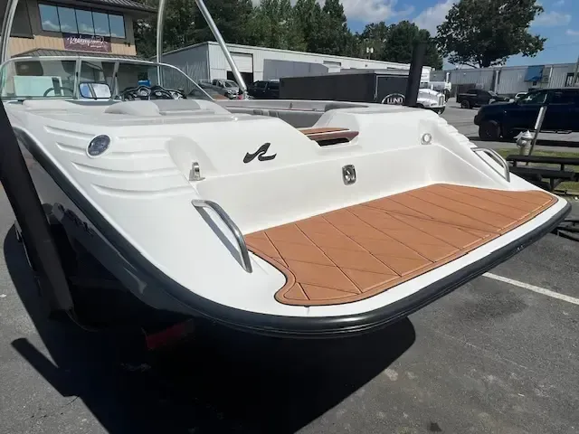 Rear view of a white and black boat with brown flooring. 