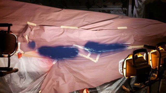 A surface covered with pink paper, marked with blue paint.