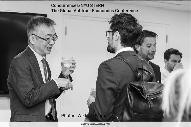Conference attendees in suits chat and drink at an NYU Stern Global Affairs Conference reception.