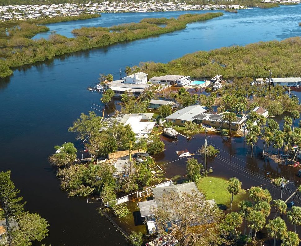 An aerial view of a flooded area with houses and trees