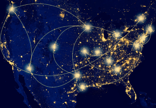 Mapa de los Estados Unidos de noche con puntos brillantes y líneas de conexión, que posiblemente representan una red o infraestructura.