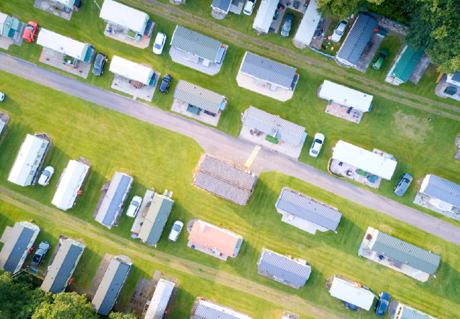 An aerial view of a row of trailers parked in a field.
