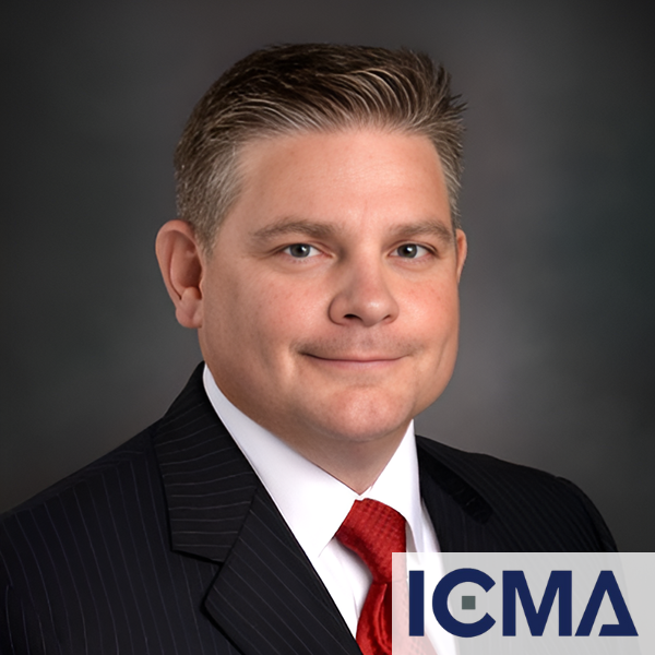 A man in a suit and tie with icma written on the bottom