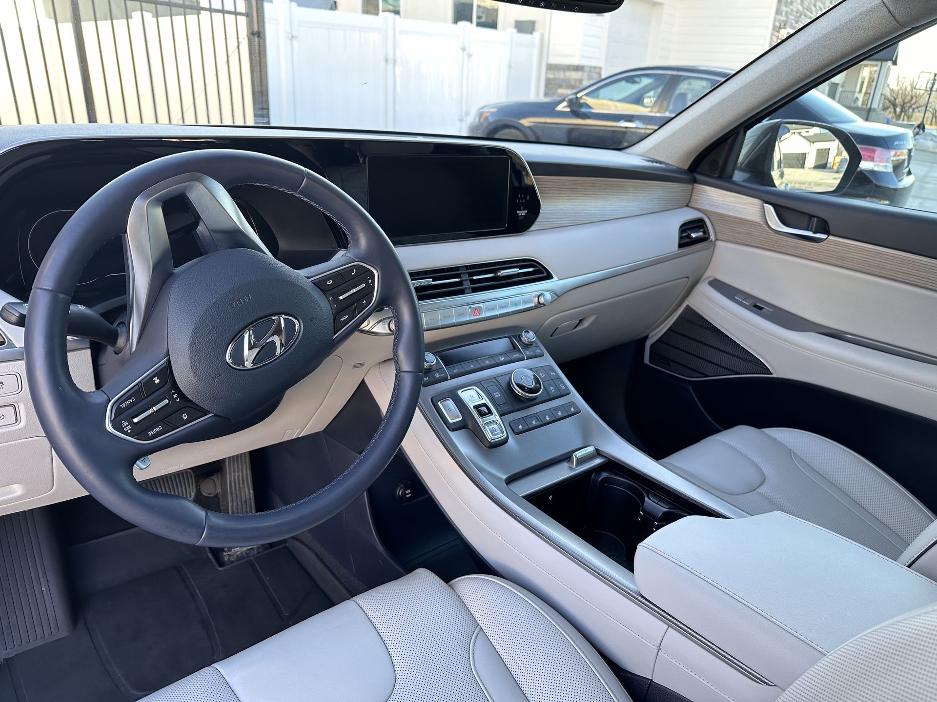 Hyundai Palisade interior with gray dashboard, steering wheel, and light-colored seats.