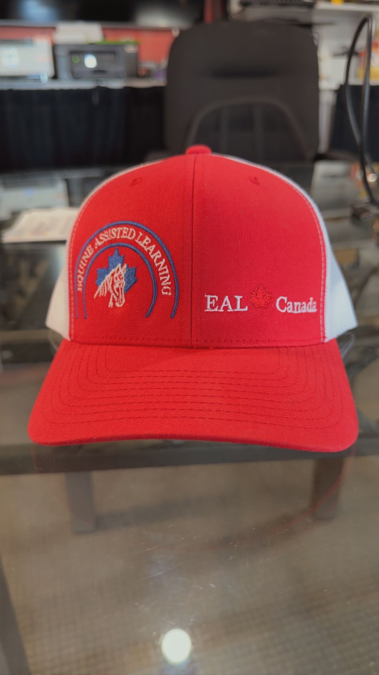 Red EAL baseball cap with embroidered logo and white text