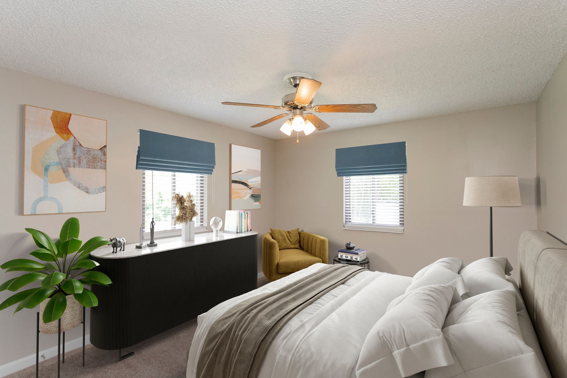 A modern bedroom with beige walls, a queen bed, a black console, a mustard armchair, and blue window shades.