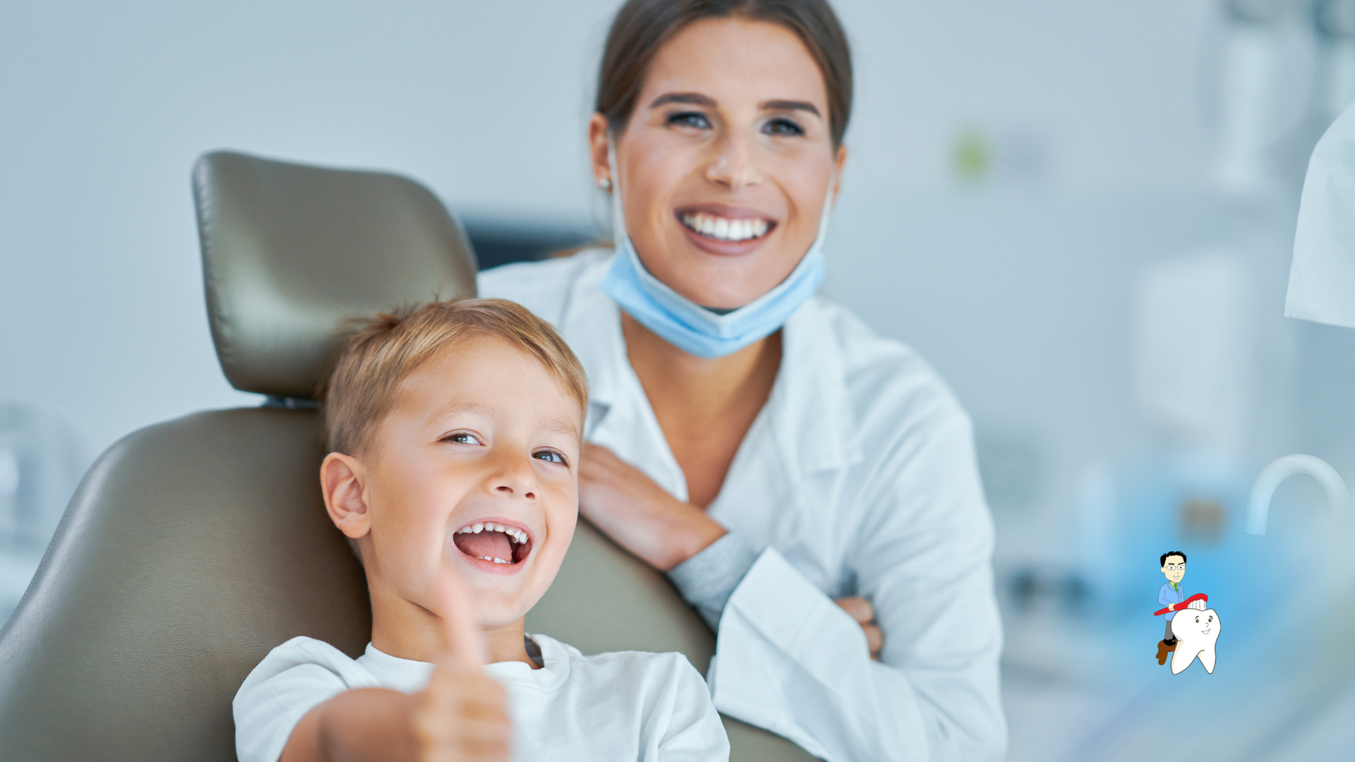 A young boy is sitting in a dental chair giving a thumbs up.