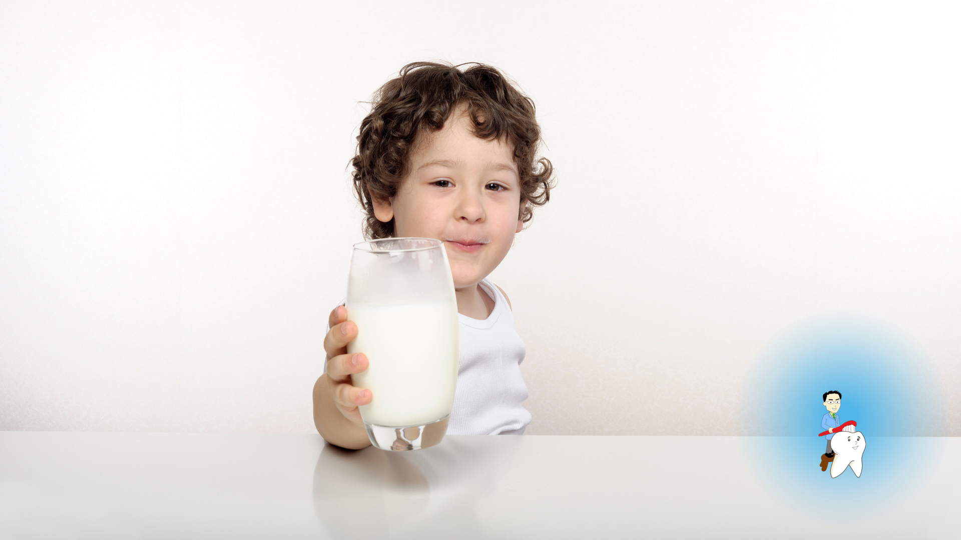 Child holding a glass of milk at a table, with a small cartoon figure in the corner.