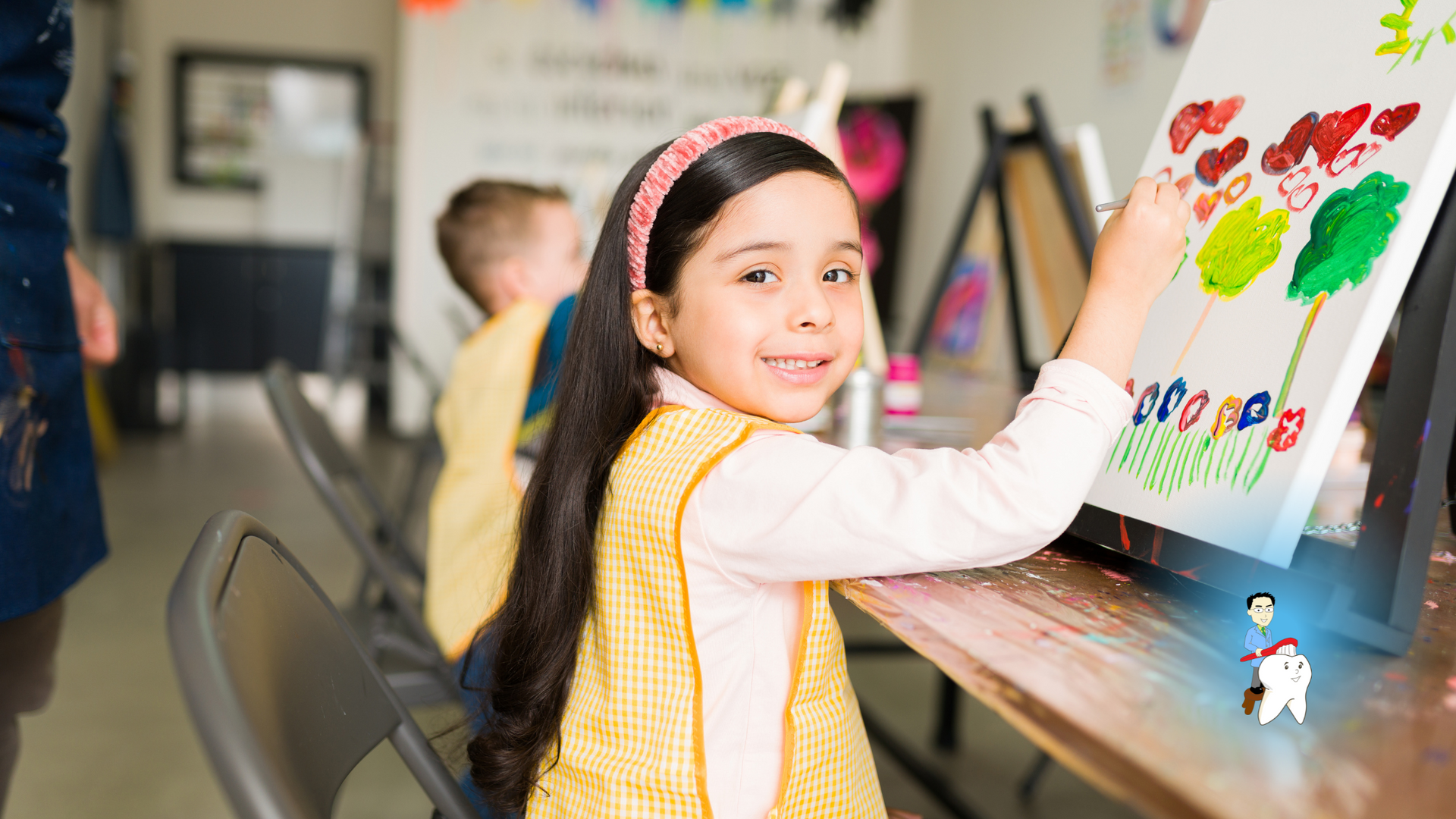 A little girl is painting on a canvas in a classroom.