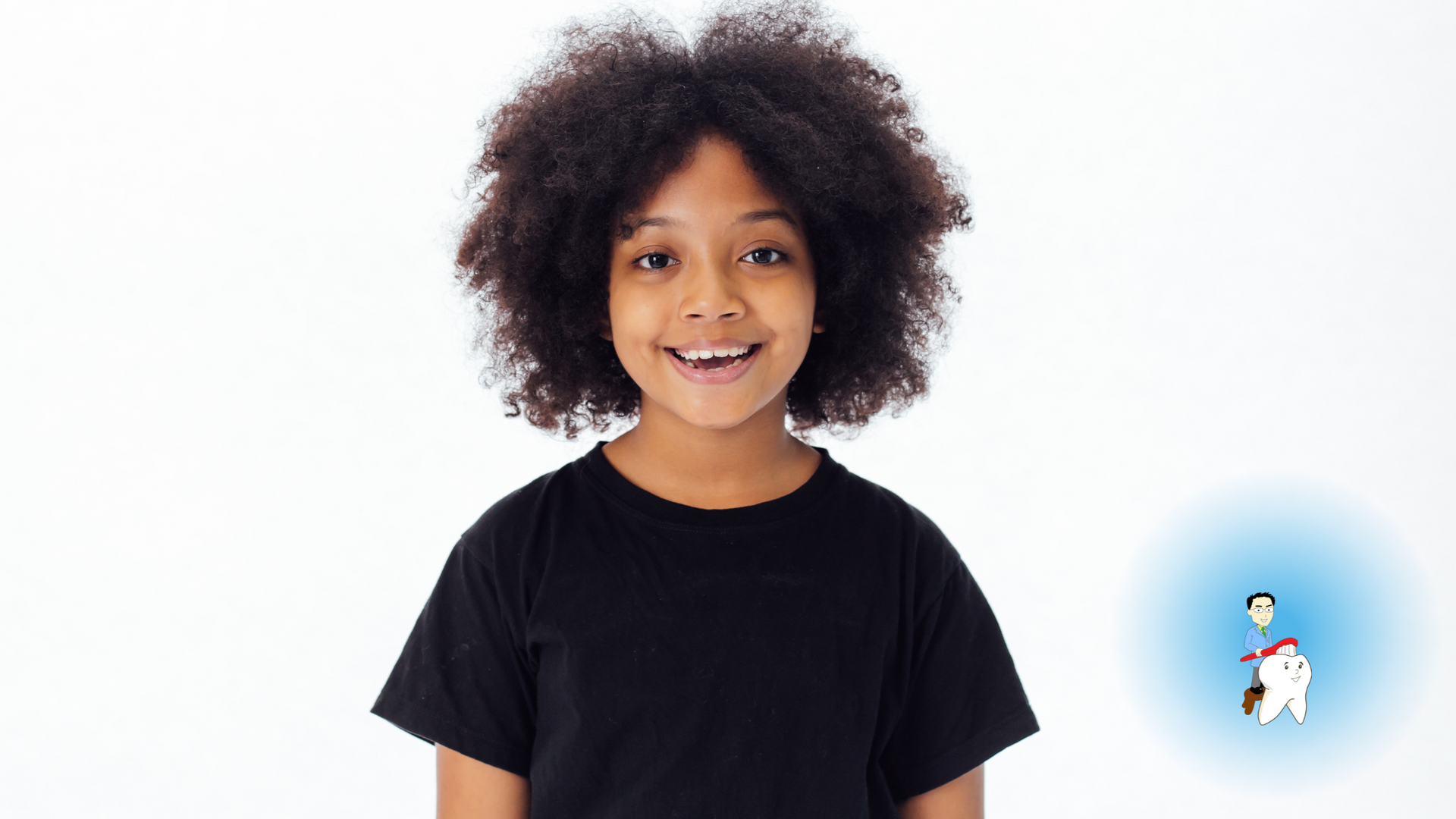 A young girl with curly hair is wearing a black shirt and smiling.