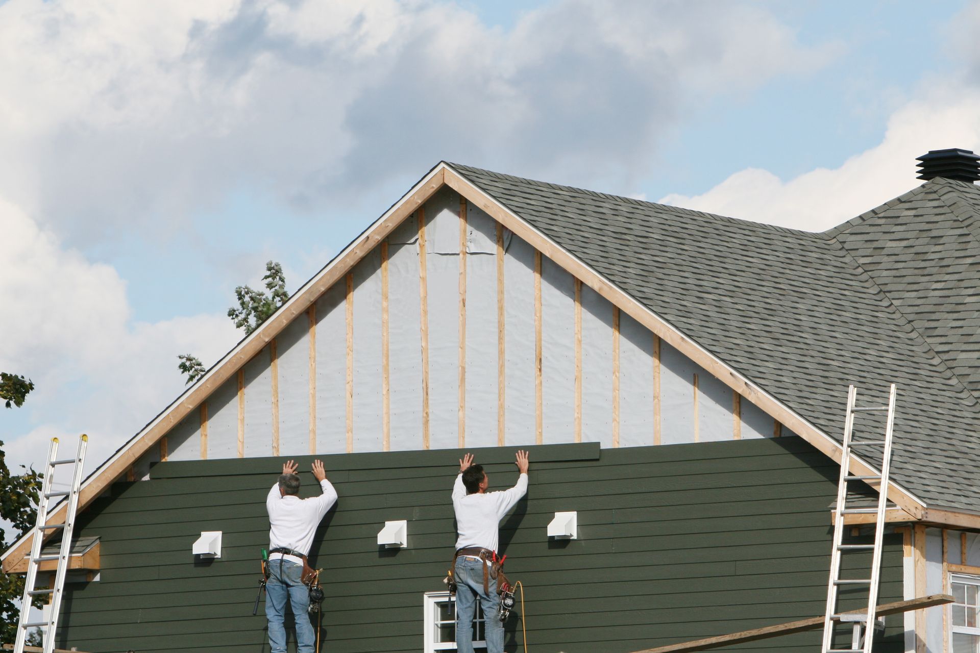 Two Men Are Working On The Side Of A House — Huron, SD — Shaddai Construction