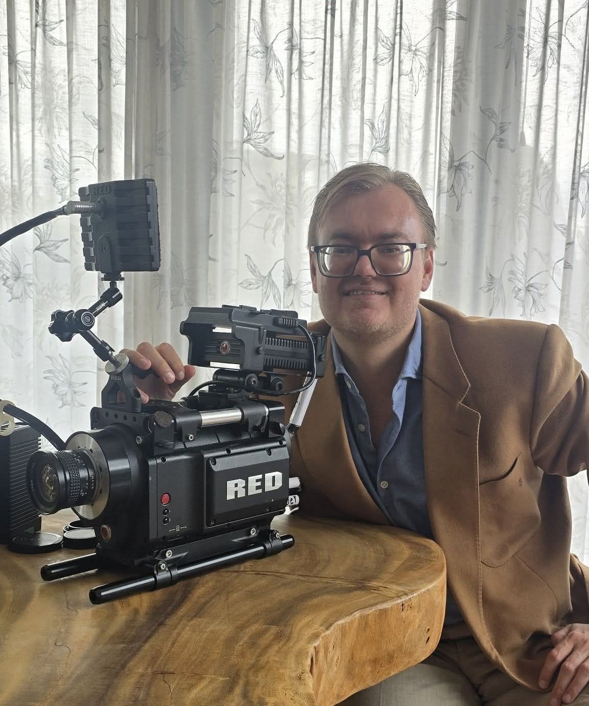 Melvin Meijer naast zijn RED-filmcamera aan een tafel