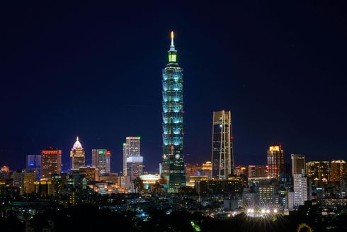 夜幕降臨,台北101大樓在漆黑的夜空中閃耀著藍色的光芒。