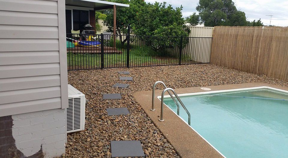 A Swimming Pool is in the Backyard of a House — Brendan's Landscaping and Fencing In Bundaberg, QLD