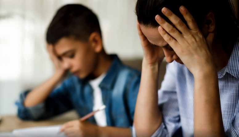 Frustrated ADHD child at desk with parent — understanding why try harder advice doesn't work
