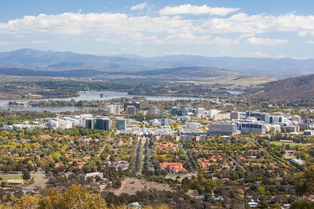 Cityscape of Canberra, Australia with buildings, lake, and mountains under a blue sky — Canberra Windscreens In Woden, ACT